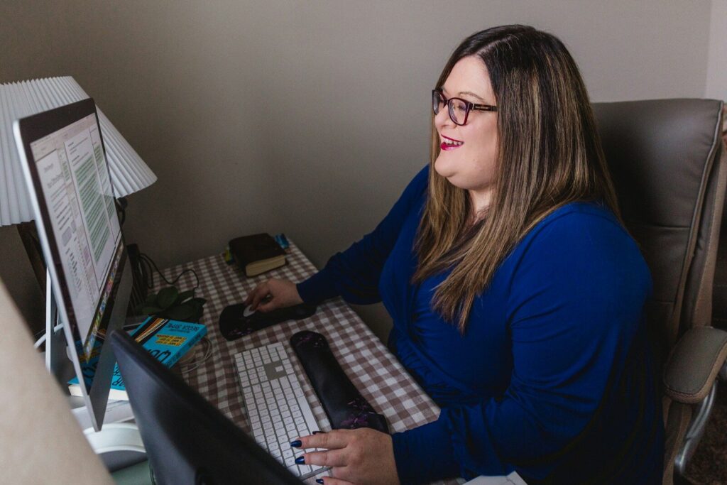 Therapist reviewing website design layout in a warm, plant-filled office